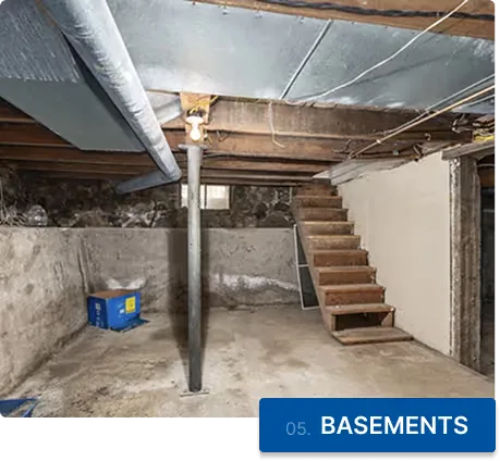 A cleared basement with open wooden stairs and a bare concrete floor
