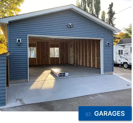 An emptied two-car garage with the door raised and bare concrete inside